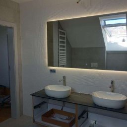 PHU Franko - Nowoczesna łazienka z podwójną umywalką nablatową, podświetlanym lustrem i dekoracyjnymi płytkami ściennymi z geometrycznym wzorem.