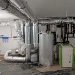 Nowoczesna kotłownia z pompą ciepła Ecoforest, rury w izolacji termicznej, filtry wody i automatyka. Instalacja w piwnicy, widok z przodu.