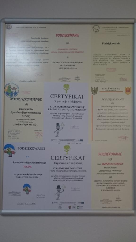 Tablica z certyfikatami i podziękowaniami dla Stowarzyszenia Pływaków i Ratowników Aqua Żyrardów oraz WOPR za kursy pierwszej pomocy i inne działania.