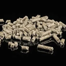 Stos pelletu drzewnego o szarej barwie na czarnym, lśniącym tle, ukazujący jego strukturę i gotowość do użycia.