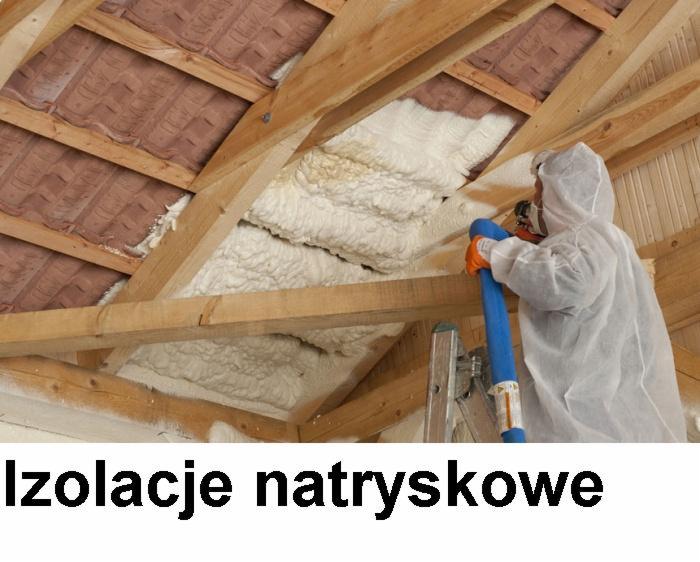 Izolacja poddasza pianą PUR: pracownik w kombinezonie natryskuje pianę na krokwie, widoczne fragmenty dachówki i drabina. Izolacje natryskowe.