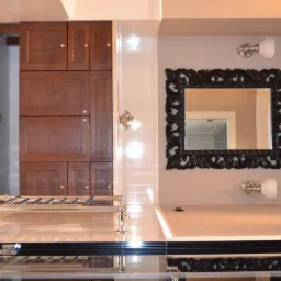 Wykończona łazienka z ciemnymi drewnianymi szafkami, ozdobnym czarnym lustrem, białymi płytkami z czarnymi akcentami i chromowanym grzejnikiem drabinkowym.