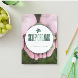 Ulotka reklamowa sklepu z żywnością organiczną 'Sklep Organik' prezentowana na jasnym tle z zielonymi winogronami, ołówkiem i notatnikiem z kluczami.