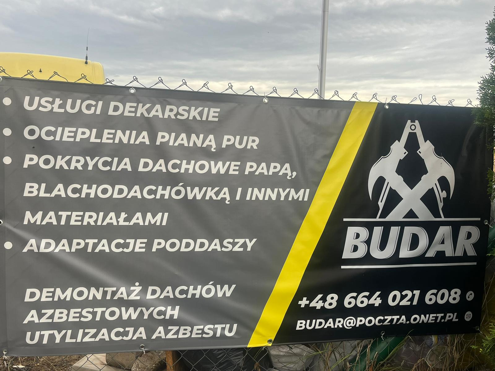 Baner reklamowy firmy BUDAR oferującej usługi dekarskie, ocieplenia pianą PUR, pokrycia dachowe, adaptacje poddaszy, demontaż dachów azbestowych i utylizację azbestu, z numerem telefonu i adresem...