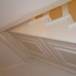 Drewkomplet Spółka z Ograniczoną Odpowiedzialnością - Kremowe schody strychowe z dekoracyjnymi panelami, widoczne od dołu, z elementami konstrukcyjnymi przymocowanymi do sufitu.