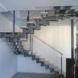 Drewkomplet Spółka z Ograniczoną Odpowiedzialnością - Nowoczesne schody z metalową konstrukcją i drewnianymi stopniami, minimalistyczny design, widok z dołu, jasne wnętrze, oryginalne mocowanie do sufitu.