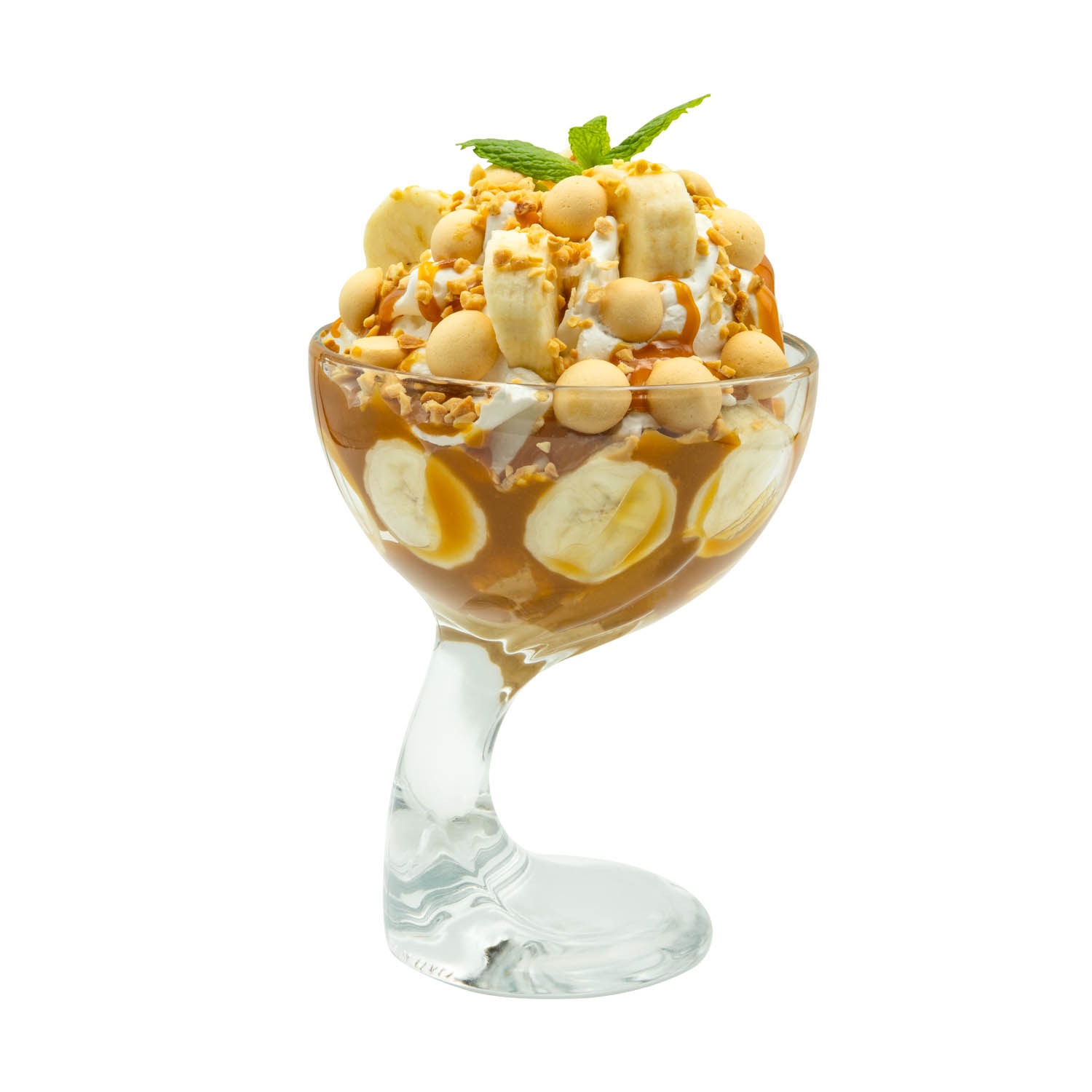 Deser lodowy w szklanym pucharku na nóżce: banany, karmel, bita śmietana, ciasteczka i mięta. Fotografia produktowa na białym tle, ostre światło.