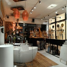 ART-FLIZ S.C. - Ekspozycja armatury łazienkowej w salonie: wolnostojąca wanna z ręcznikiem, umywalka nablatowa, baterie, panele prysznicowe i oświetlenie dekoracyjne