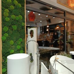 ART-FLIZ S.C. - Nowoczesna łazienka z wolnostojącą umywalką cylindryczną, obok panel z mchu, w tle wanna i lampa wisząca.