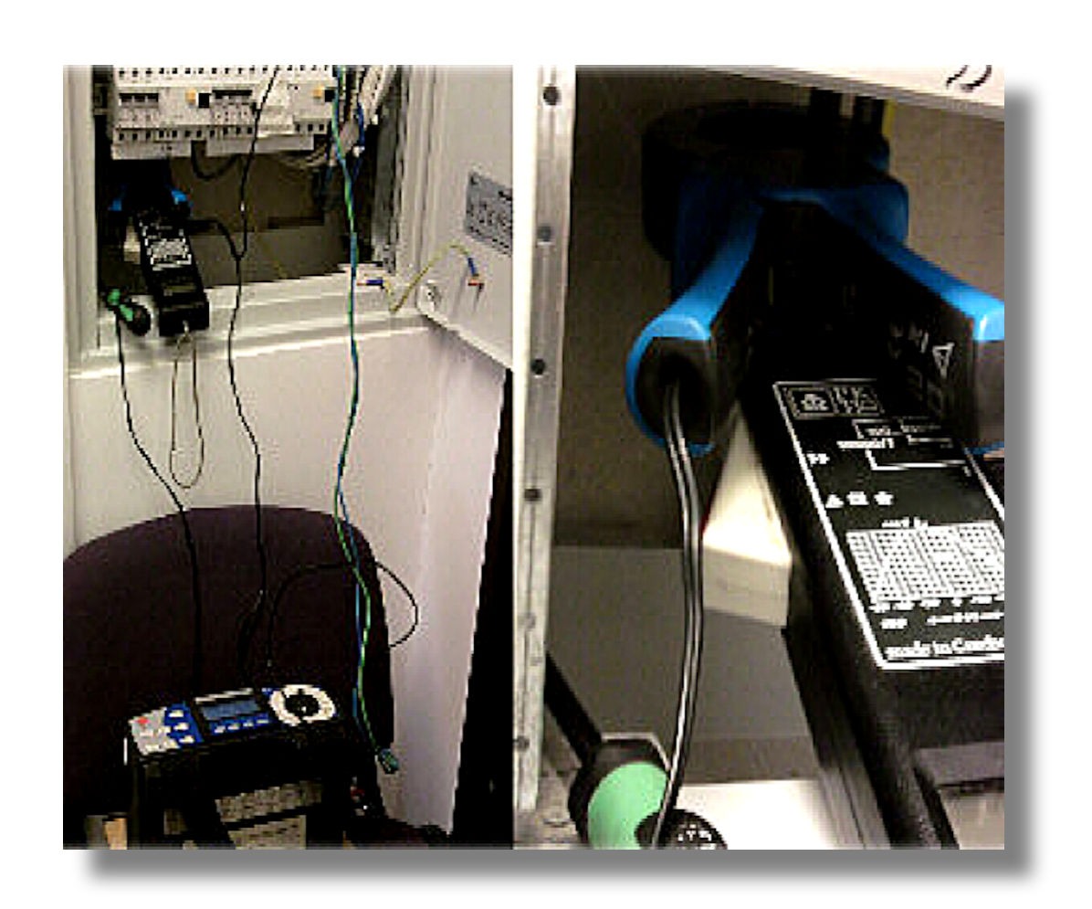 Miernik cęgowy i multimetr podczas pomiarów w skrzynce elektrycznej. Widoczne przewody i elementy instalacji. Sprzęt pomiarowy na krześle.