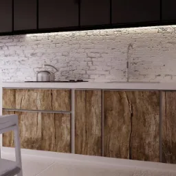 Nowoczesna kuchnia z białymi cegłami na ścianie, drewnianymi frontami szafek i białym stołem z krzesłami. Na blacie czajnik ze stali nierdzewnej.