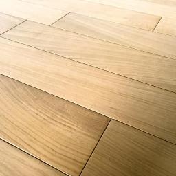 Wood & Iron Manufacture - Jasna, drewniana podłoga ułożona z desek pod kątem, ukazująca naturalny rysunek drewna i precyzję wykonania. Widoczne subtelne różnice w odcieniach poszczególnych desek.