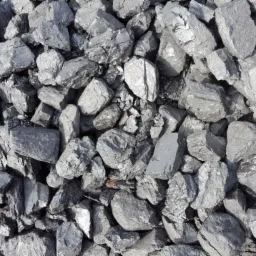 Błyszczące bryły ekogroszku w pojemniku, widoczne drobne pęknięcia i struktura węgla, oświetlone naturalnym światłem, wypełniające kadr.