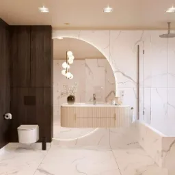 Elegancka łazienka z marmurowymi płytkami, podświetlanym lustrem w kształcie półksiężyca, wiszącą szafką umywalkową z ryflowanym frontem i nowoczesną armaturą.
