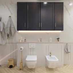 Elegancka łazienka w odcieniach bieli i złota z marmurowymi ścianami, czarnymi szafkami wiszącymi, toaletą, bidetem, złotym koszem na śmieci i złotymi akcentami, widoczne szlafroki i ręczniki.