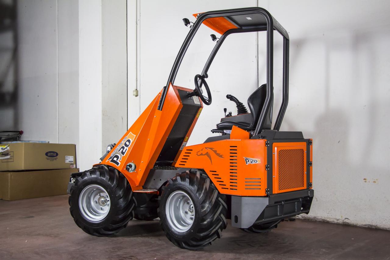 Pomarańczowa miniładowarka Horse Tractor P20 z czarną kabiną ochronną, widoczna z boku, na tle magazynu z kartonami.