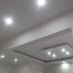 Biały sufit podwieszany z oświetleniem punktowym LED, widoczne elementy konstrukcyjne i gładkie wykończenie.