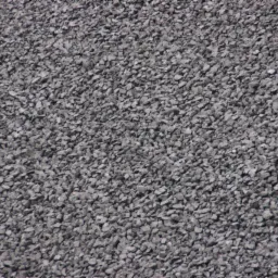 Detaliczne ujęcie szarego ekogroszku o nieregularnych kształtach, wypełniającego całą powierzchnię kadru, z subtelnymi zmianami w odcieniach szarości.