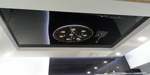 Nowoczesny sufit podwieszany z czarnym lustrzanym panelem i okrągłym oświetleniem LED. Minimalistyczny design, precyzyjne wykonanie.