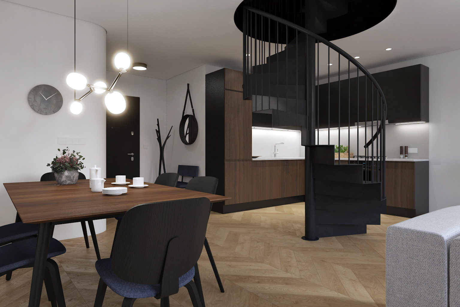 Nowoczesne wnętrze: drewniany stół z nakryciem, czarne krzesła, spiralne schody, parkiet w jodełkę, minimalistyczna kuchnia z drewnianymi frontami, designerska lampa sufitowa.