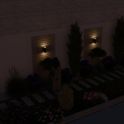 OGRODOWY KREATOR Iwona Falęcka - Oświetlony ogród w Działdowie nocą: ścieżka z płyt, rabaty kwiatowe, drzewa i pergola z oświetleniem. Dekoracyjne panele z lampami na ścianie budynku.