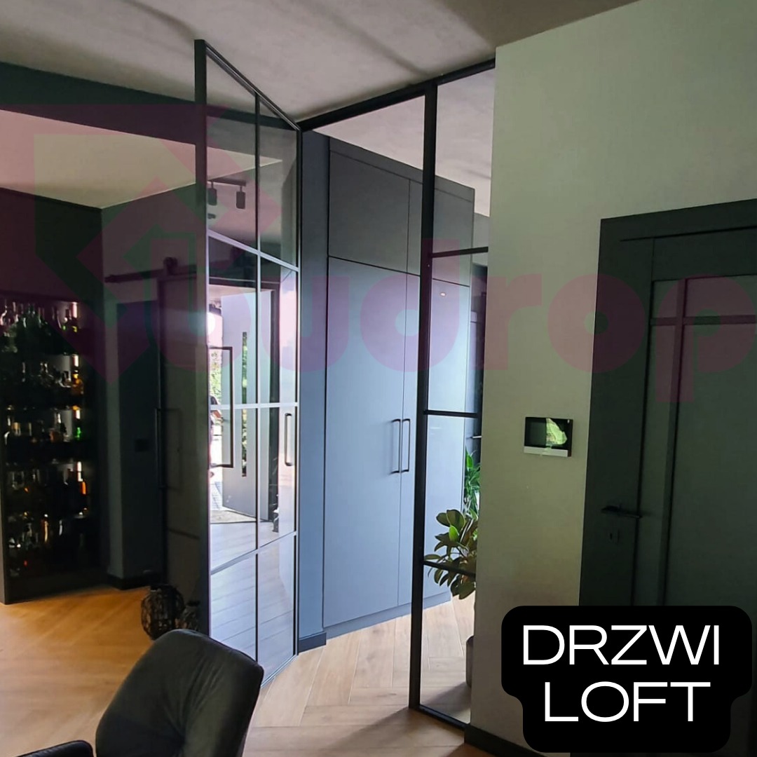 Nowoczesne drzwi loftowe z czarnymi szprosami, w tle zabudowa meblowa w szarym kolorze i parkiet ułożony w jodełkę.