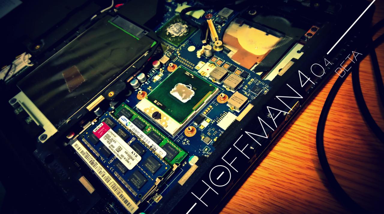Otwarty laptop z widoczną płytą główną, procesorem, pamięcią RAM i elementami chłodzenia na drewnianym biurku. Napis 'HOFFMAN 4.0.4 BETA' na obudowie.