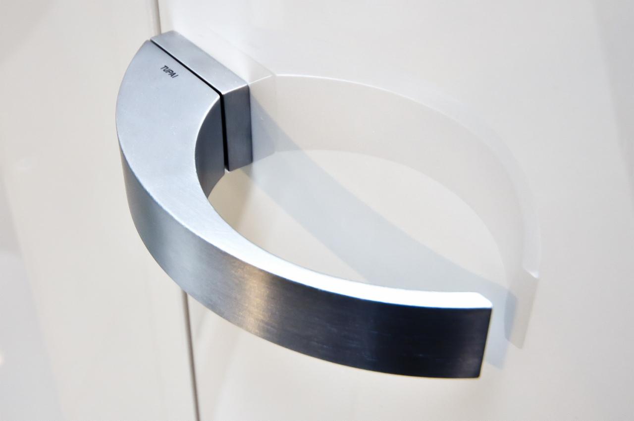 Szczegółowe ujęcie metalowej klamki Tupai w kształcie półkola, zamontowanej na białym skrzydle Ardago Stratos.