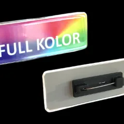 Dwie plastikowe identyfikatory z tęczowym gradientem i napisem 'FULL KOLOR', widok z przodu i z tyłu z zapięciem na agrafkę.