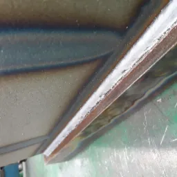 Spoina pachwinowa wykonana na grubej blasze, widoczne przebarwienia termiczne i ślady po spawaniu.