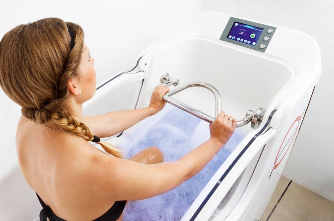 Kobieta w nowoczesnej wannie z hydromasażem z panelem sterowania, woda z bąbelkami, widok z góry.