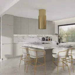 Jasna kuchnia z marmurowym blatem i złotymi akcentami, krzesła barowe z welurowym siedziskiem i złotymi nogami, nad wyspą złoty okap w formie cylindra, minimalistyczne szafki bez uchwytów.