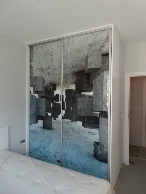 Przesuwna szafa w sypialni z fotorealistyczną grafiką betonowych sześcianów tworzących iluzję głębi.