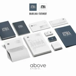 Kompletna identyfikacja wizualna marki ATMA: wizytówki, papier firmowy, notesy, koperty i teczki, prezentowane na białym tle. Elegancki minimalizm w granatowo-białej kolorystyce.