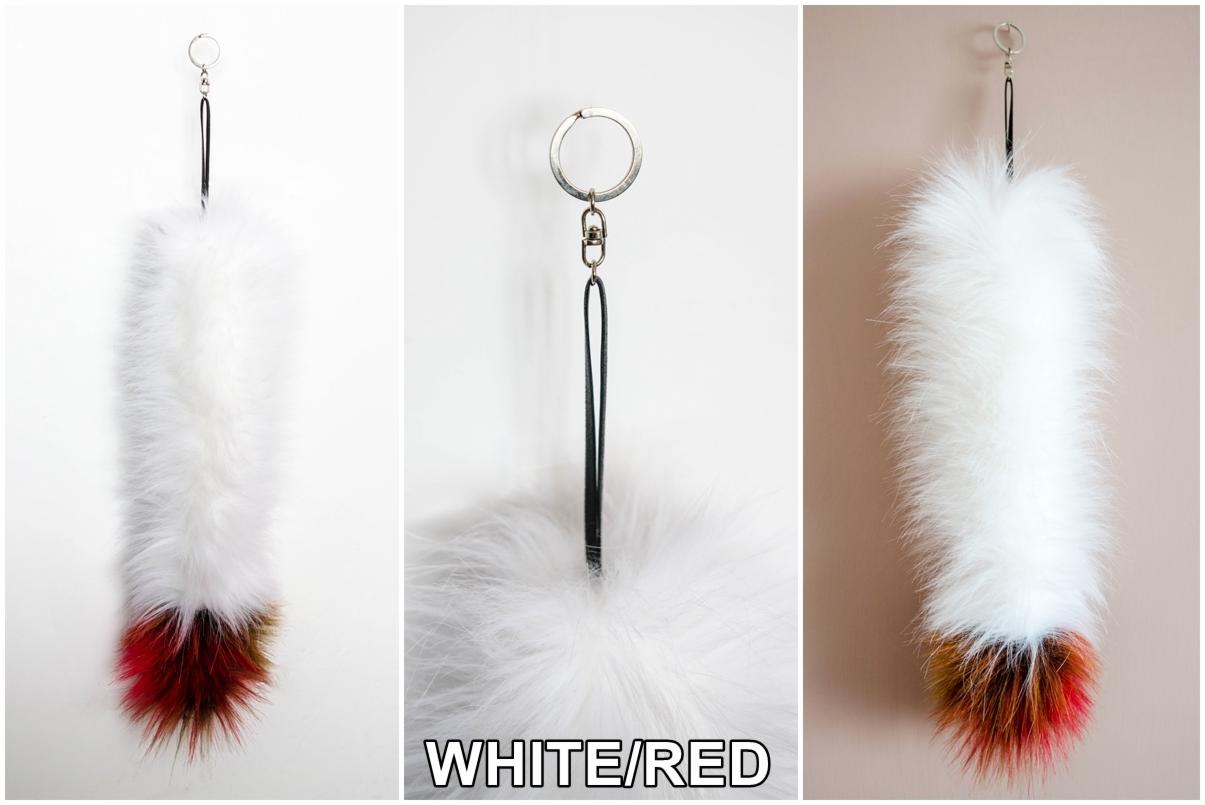 Trzy ujęcia białego, futrzanego breloczka z czerwono-brązowym końcem, zawieszonego na srebrnym kółku z czarnym rzemykiem.
