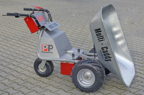 Elektryczna taczka PowerPac Multi-Caddy MCE 100 z aluminiową skrzynią na trzech kołach, na kostce brukowej, z widocznymi detalami konstrukcyjnymi.