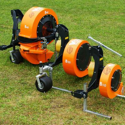 Pomarańczowa, mobilna dmuchawa do liści B40, B20 i B10 na trawniku. Dmuchawa ma czarne elementy i koła. Widoczne detale konstrukcyjne i numery modeli.