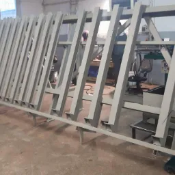 Konstrukcja metalowa w warsztacie z widocznymi spawami i elementami mocującymi, przygotowana do dalszej obróbki lub montażu.