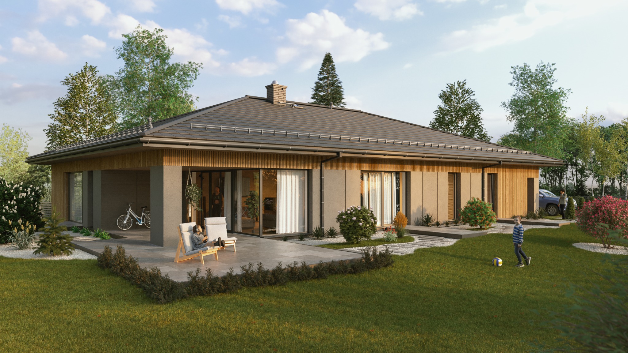 Parterowy dom z szarą dachówką i drewnianą elewacją, widok z ogrodu. Na tarasie leżaki, w tle rower. Chłopiec gra w piłkę na trawniku. Za domem zaparkowany samochód.