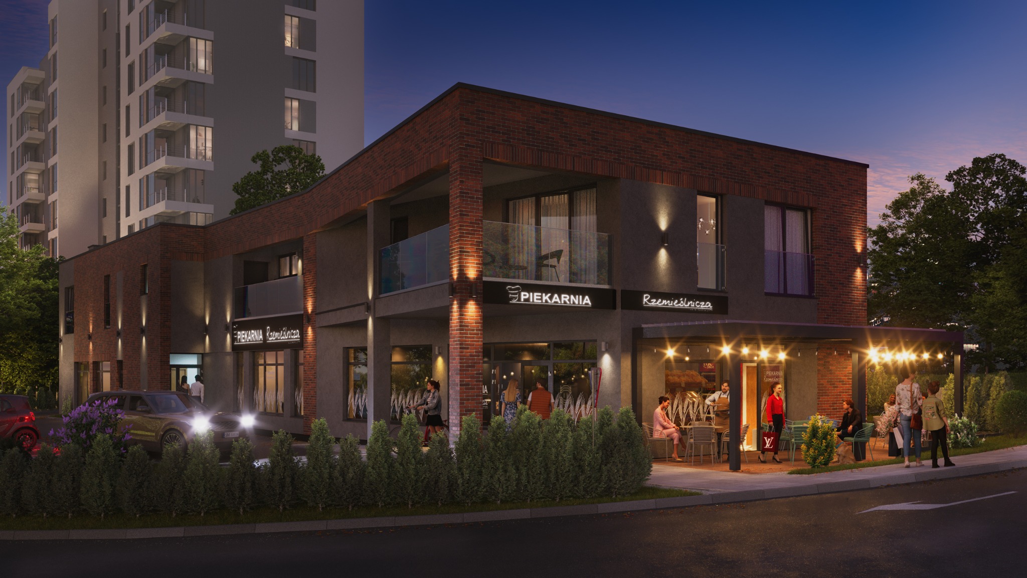 Dwukondygnacyjny budynek usługowy z ceglaną elewacją i oświetleniem zewnętrznym. Widoczne szyldy 'Piekarnia Rzemieślnicza' i stoliki z klientami przed lokalem.