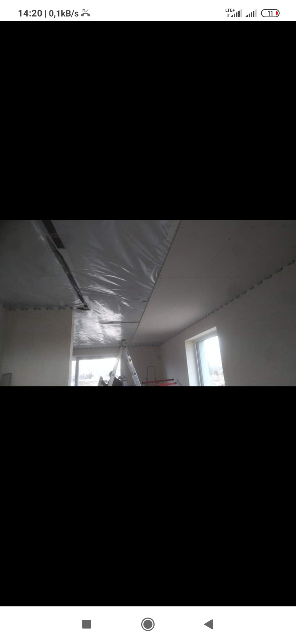 Montaż folii paroizolacyjnej na suficie podwieszanym, widoczna drabina i okno w tle.