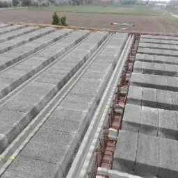 Wykonywanie stropu Teriva z betonowych pustaków szalunkowych i zbrojenia w Płocku, widok z góry na ułożone elementy.