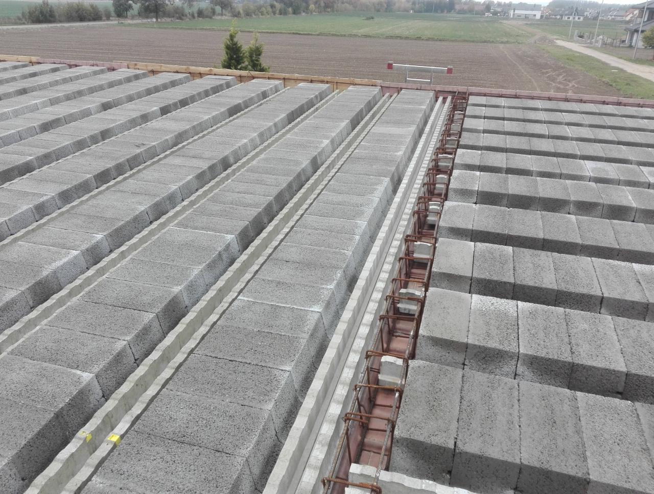 Wykonywanie stropu Teriva z betonowych pustaków szalunkowych i zbrojenia w Płocku, widok z góry na ułożone elementy.