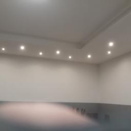 Zano - Pomieszczenie po gładziowaniu ścian i sufitu z widocznym oświetleniem punktowym w suficie podwieszanym.