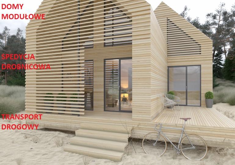 Nowoczesny dom z jasnego drewna z charakterystycznymi poziomymi listwami, rower oparty o taras, widok z zewnątrz na tle piaszczystego terenu i lasu.