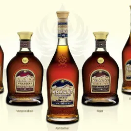 Różne butelki armeńskiego brandy Ararat, każda z innym oznaczeniem wieku i nazwą, ustawione obok siebie na jasnym tle.