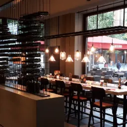 Regał na wino wykonany z materiału corian oraz prętów metalowych malowanych na czarno