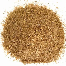 Kopuła z brązowych, drobnych wiórów na białym tle, przypominająca agropellet z widocznymi fragmentami drewna.