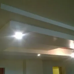 Wykończony sufit podwieszany z oświetleniem punktowym, widok z dołu, jasne refleksy świetlne.