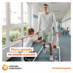 Fizjoterapeutka pomaga mężczyźnie z zabandażowanym kolanem ćwiczyć chodzenie przy barierkach w jasnym, przestronnym gabinecie rehabilitacyjnym.